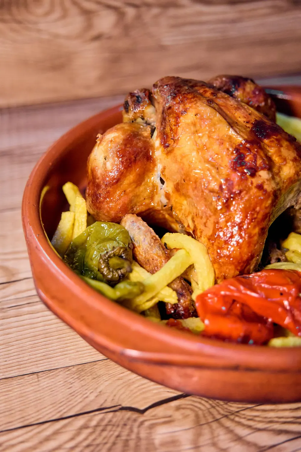 Pollo asado con patatas fritas y pimientos en cazuela